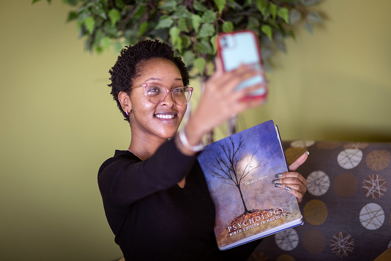 Proud Student Takes Selfie with Textbook