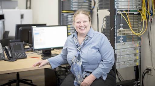 Julie, a Madison College IT student sitting at computer in lab classroom